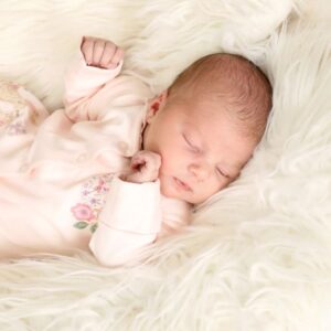 Sleeping baby girl newborn on a fluffy blanket