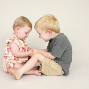 6 month old baby and big brother 2 years old holding hands smiling cute sibling photo