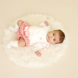 3 month old baby laying on fluffy rug with socks